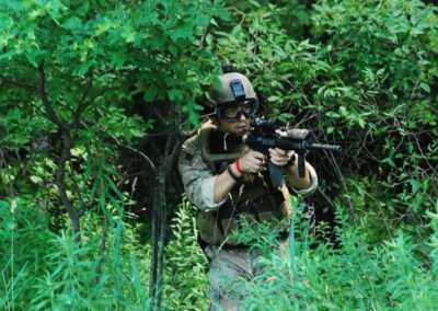 Airsoft player preparing to fire in the brush at Cousins Paintball